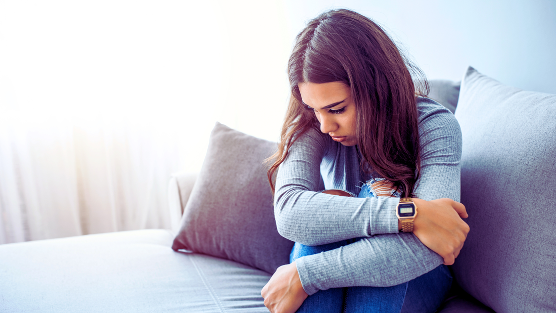 girl looking sad and downtrodden sitting on a bed with her arms crossed, levels of mental health care, behavioral health, integrated health, inpatient treatment, outpatient treatment, anxiety disorder
