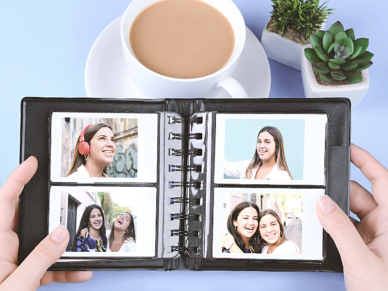 blue background with coffee and two small succulents, hands holding photo album full of teenage sisters, 4x6 photo albums, photo albums online, pioneer photo albums, large photo albums, best photo albums, photo albums michaels, photo albums amazon